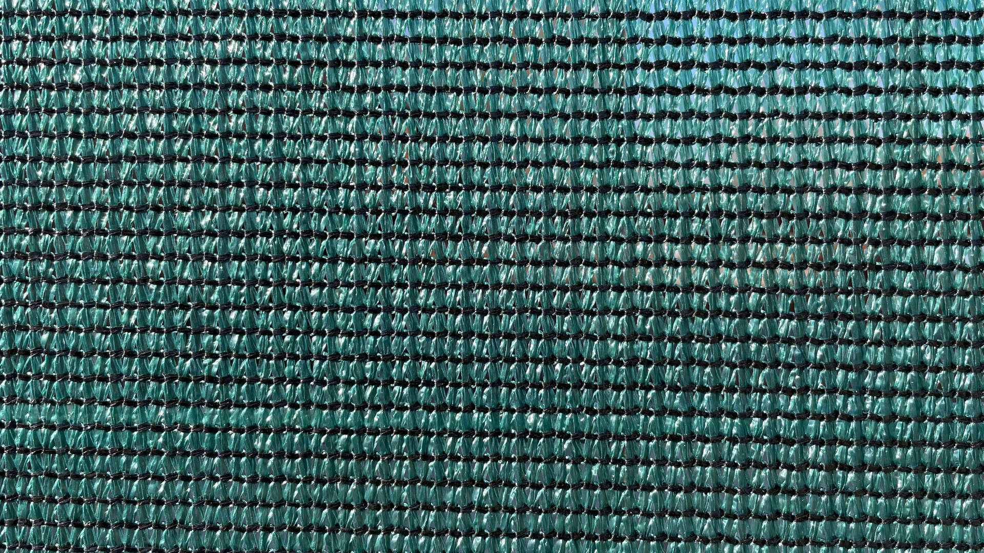 Stínící tkanina zelené barvy, 90%, 180 g/m² – detailní záběr na strukturu ok.