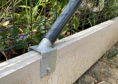Podhrabová betonová deska pod plot jako náhrada podezdívky – detail uchycení držáku na plotovou vzpěru.